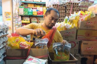 Salah satu pedagang sedang mengeluarkan MinyakKita kemasan di Pasar Cibubur, Kecamatan Ciracas, Jakarta Timur, Selasa (31/1). Foto: Ist