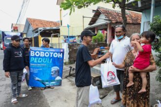 Para relawan Ganjar Muda Padjajaran (GMP) membagikan makanan ke masyarakat membutuhkan di Jalan Karang Jalak, Kelurahan Sunyaragi, Kecamatan Kesambi, Kota Cirebon, Jawa Barat (Jabar). Foto: GMP