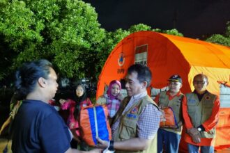 Petugas Badan Nasional Penanggulangan Bencana (BNPB) membangun tenda untuk warga yang mengungsi dan memberikan sejumlah bantuan kepada para korban terdampak kebakaran Depo Pertamina Plumpang, Jakarta Utara, Sabtu (4/3) malam. Foto: BNPB