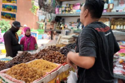 Pedagang kurma di Pasar Jatinegara, Kelurahan Bali Mester, Kecamatan Jatinegara, Jakarta Timur, sedang melayani pembeli, Senin (20/3). Foto: Joesvicar Iqbal/ipol.id
