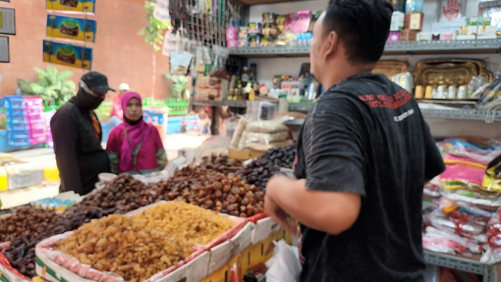 Pedagang kurma di Pasar Jatinegara, Kelurahan Bali Mester, Kecamatan Jatinegara, Jakarta Timur, sedang melayani pembeli, Senin (20/3). Foto: Joesvicar Iqbal/ipol.id