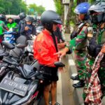 Dua personel TNI mengamankan tiga remaja yang membawa senjata tajam berukuran besar disembunyikan dalam kain sarung di Jalan Raya TMII, Makasar, Jakarta Timur. Foto: TNI