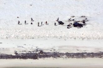 Para nelayan dari Indonesia berdiri di sebuah pantai di Pulau Bedwell, 313 kilometer sebelah barat Broome, Australia, Senin, 17 April 2023. (Otoritas Keselamatan Maritim Australia via AP)