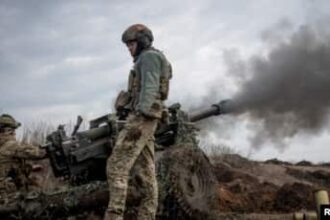 Anggota dinas Ukraina menembakkan howitzer M119 ke garis depan, di tengah serangan Rusia ke Ukraina, dekat Kota Bakhmut, Ukraina 10 Maret 2023. (Foto: REUTERS/Oleksandr Ratushniak)