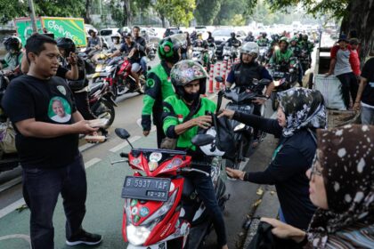 Pengendara ojek online (ojol) maupun pengguna jalan lain menerima makanan takjil dari Komunitas Warung Tegal (Kowarteg) Indonesia di kawasan Bendungan Hilir, Tanah Abang, Jakarta Pusat, Jumat (31/3). Foto: Kowarteg.