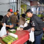 Sukarelawan Ganjar Muda Padjajaran (GMP) berbagi makanan sahur ke para pedagang pasar di kawasan Ujung Berung, Bandung, Jawa Barat, Minggu (16/4) dini hari. Foto: GMP