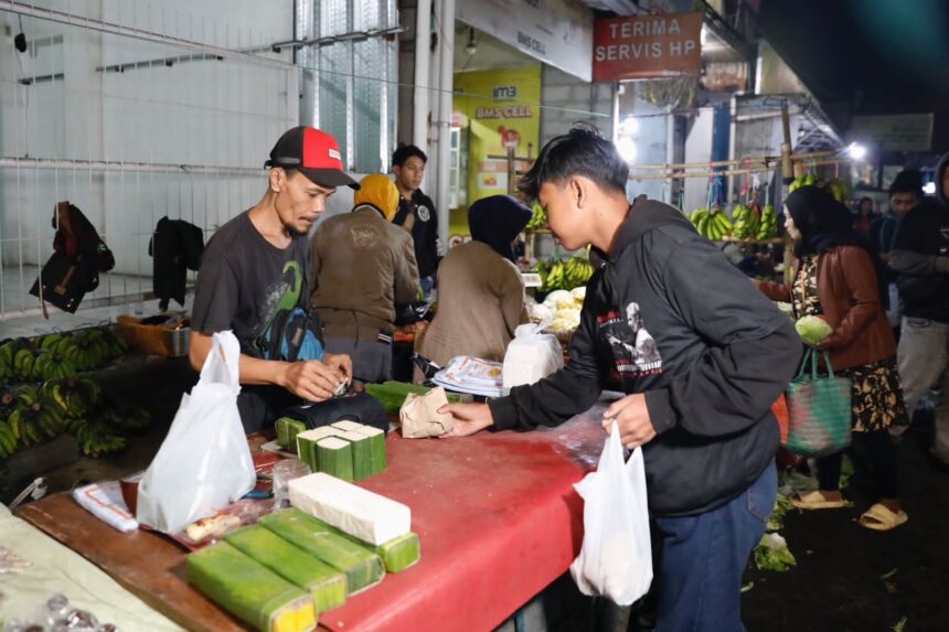 Sukarelawan Ganjar Muda Padjajaran (GMP) berbagi makanan sahur ke para pedagang pasar di kawasan Ujung Berung, Bandung, Jawa Barat, Minggu (16/4) dini hari. Foto: GMP