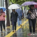 Warga menggunakan payung saat hujan di kawasan Semanggi Jakarta. (ANTARA FOTO)
