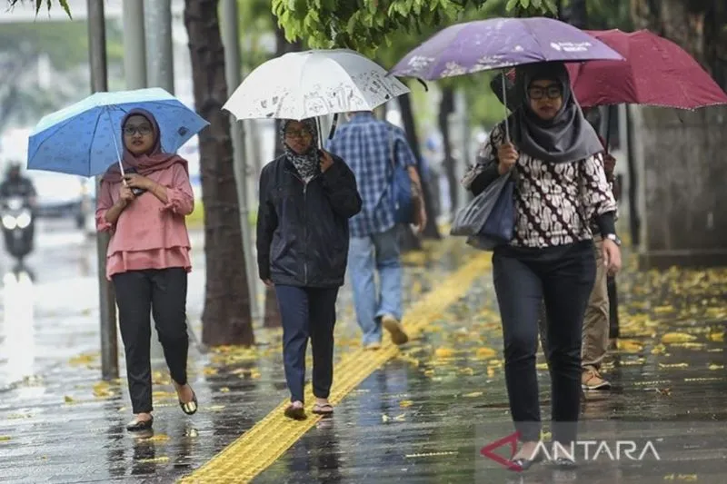 Warga menggunakan payung saat hujan di kawasan Semanggi Jakarta. (ANTARA FOTO)