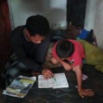 Abdullah mengajarkan anaknya yakni Alka, 8, untuk belajar membaca, berhitung dan mengaji di sebuah ruangan tempat keduanya menumpang di pos keamanan cafe tempatnya bekerja di kawasan Kalisari, Jakarta Timur, Jumat (14/4). Foto: Ist
