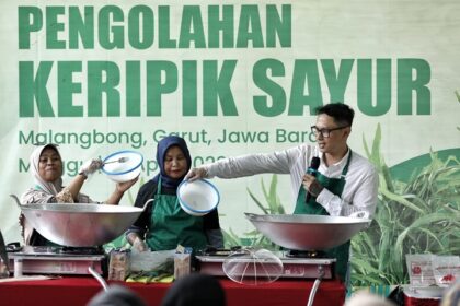 Relawan Ganjar Muda Padjajaran (GMP) membuat keripik kangkung krispi di rumah produksi keripik di Desa Bunisari, Kecamatan Malangbong, Kabupaten Garut, Jawa Barat, Minggu (16/4). Foto: GMP