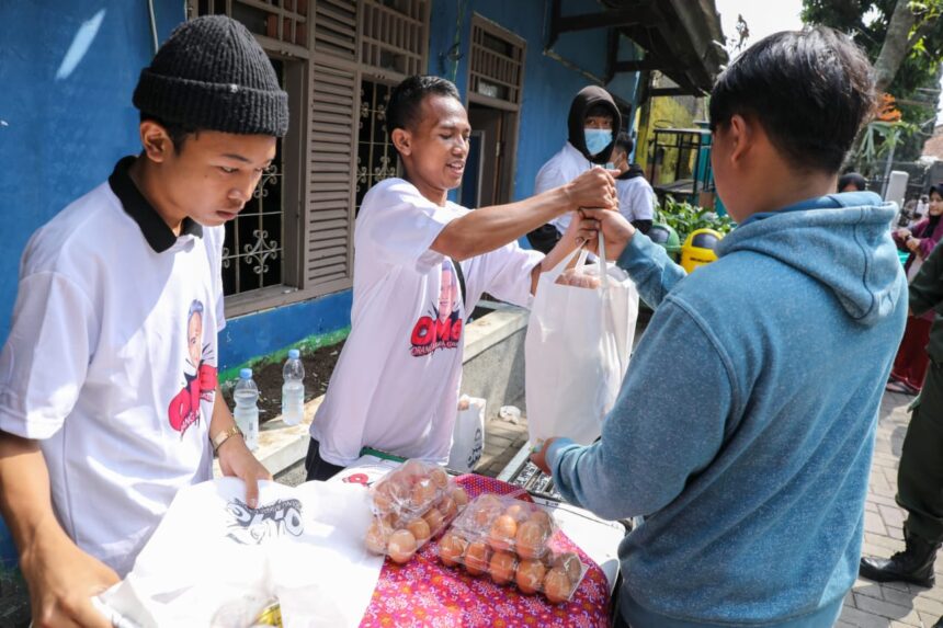 Ratusan warga Kelurahan Babakan Tarogong, Kecamatan Bojongloa Kaler, Kota Bandung antri untuk membeli sembako di pasar murah yang diadakan oleh relawan Orang Muda Ganjar (OMG) Jawa Barat (Jabar) pada Sabtu (20/5) pagi. Foto: OMG