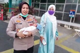 Kapolsek Kramat Jati, Kompol Tuti Aini bergegas membawa bayi mungil ke Puskesmas Kelurahan Kramat Jati, Jakarta Timur untuk penanganan medis awal, Rabu (24/5) siang. Foto: Ist