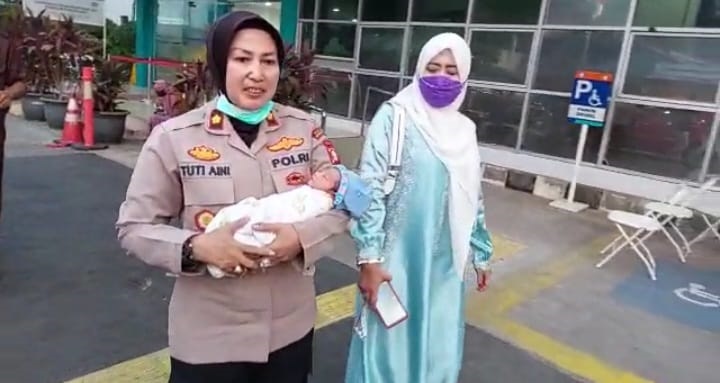 Kapolsek Kramat Jati, Kompol Tuti Aini bergegas membawa bayi mungil ke Puskesmas Kelurahan Kramat Jati, Jakarta Timur untuk penanganan medis awal, Rabu (24/5) siang. Foto: Ist