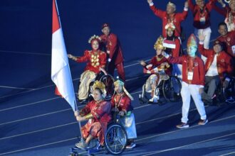 Atlet putri para angkat berat Indonesia, Dwiska Afrilia Maharani, mendapat kehormatan menjadi pembawa Bendera Merah Putih pada upacara pembukaan Asean Para Games 2023 Kamboja. Foto: Kemenpora