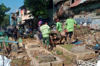 Sejumlah petugas Sudin Pertamanan dan Hutan Kota Jakarta Timur menertibkan pagar dan kandang hewan di Taman Pemakaman Umum (TPU) Prumpung, Kelurahan Cipinang Besar Utara, Kecamatan Jatinegara, Jakarta Timur yang sebelumnya kumuh dijadikan tempat jemuran hingga kandang ayam, burung dan kambing, Senin (12/6) siang. Foto: Ist