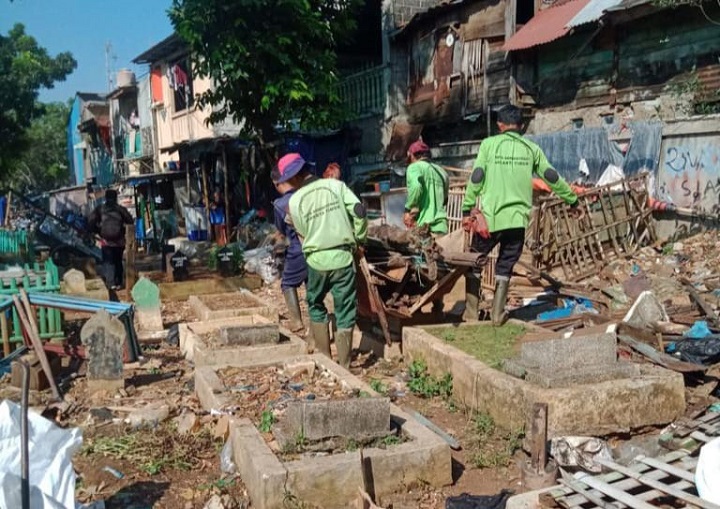 Sejumlah petugas Sudin Pertamanan dan Hutan Kota Jakarta Timur menertibkan pagar dan kandang hewan di Taman Pemakaman Umum (TPU) Prumpung, Kelurahan Cipinang Besar Utara, Kecamatan Jatinegara, Jakarta Timur yang sebelumnya kumuh dijadikan tempat jemuran hingga kandang ayam, burung dan kambing, Senin (12/6) siang. Foto: Ist