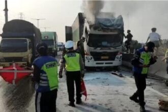 Tampak sejumlah petugas tol dan kepolisian melakukan pemadaman api yang keluar dari kepala truk tersebut. Foto: Polri
