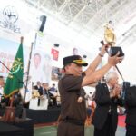 Kepala Kejaksaan Tinggi Sulawesi Selatan, Leonard Eben Ezer Simanjuntak mengangkat trophy tanda dimulainya Kejuaraan Nasional Karate Jaksa Agung Cup I. Foto: Seksi Penkum Kejati Sulsel