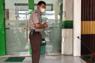 Petugas keamanan menunjukkan posisi bangku stainless steel yang raib di tempat Pegadaian di Jalan Kelapa Dua Wetan, Kecamatan Ciracas, Jakarta Timur, Kamis (27/7). Foto: Joesvicar Iqbal/ipol.id