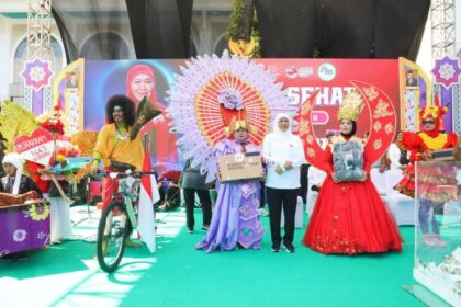 Gubernur Jawa Timur Khofifah Indar Parawansa saat menyerahkan hadiah kepada peserta jalan di Jalan Sehat 1 Muharram 1445 H di Masjid Nasional Al Akbar Surabaya, Rabu (19/7). Foto: Ist