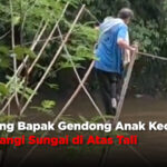 Seorang Bapak Gendong Anak Kecil Seberangi Sungai di Atas Tali