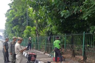 Sudin Taman Hutan Jakarta Timur memasang pagar pada bagian-bagian besi yang hilang di Hutan Kota UKI Cawang, Kebon Pala, Makasar, Rabu (26/7) siang. Foto: Ist