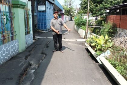 Ketua RW 07 Cawang, Munadi menunjukkan Jalan Mesjid Bendungan, Kelurahan Cawang, Kecamatan Kramat Jati, Jakarta Timur, Sabtu (8/7) siang yang ambles 50 meter dan belum diperbaiki. Foto: Joesvicar Iqbal/ipol.id