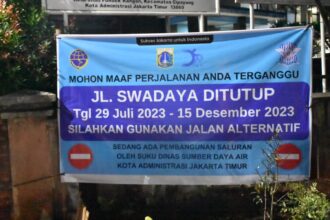 Spanduk pemberitahuan penutupan Jalan Swadaya, Kelurahan Pondok Ranggon, Kecamatan Cipayung, Jakarta Timur dilakukan mulai tanggal 29 Juli hingga 15 Desember 2023, Senin (31/7). Foto: Joesvicar Iqbal/ipol.id