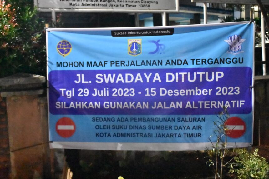 Spanduk pemberitahuan penutupan Jalan Swadaya, Kelurahan Pondok Ranggon, Kecamatan Cipayung, Jakarta Timur dilakukan mulai tanggal 29 Juli hingga 15 Desember 2023, Senin (31/7). Foto: Joesvicar Iqbal/ipol.id