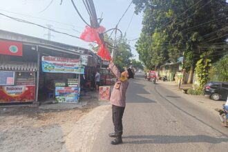 Aparat Polsek Jagakarsa mengamankan kabel semrawut terjuntai membahayakan pengguna jalan, terjadi di Jalan Srengseng Sawah, RT 005/RW 06, Kel. Srengseng Sawah, Jagakarsa, Jakarta Selatan, Minggu (6/8) siang. Foto: Ist