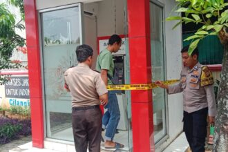 Aparat Polsek Cipayung memasang garis police line pada Anjungan Tunai Mandiri (ATM) Bank DKI di kantor Kelurahan Cilangkap, Cipayung, Jakarta Timur, usai terjadi dugaan kasus ganjal ATM belum lama ini. Foto: Ist