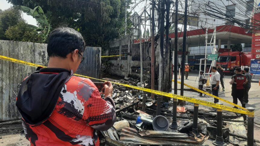 Aparat kepolisian memberikan garis police line pada kios tambal ban sekaligus penjual bensin eceran yang kebakaran di Jalan Raya Matraman, Kebon Manggis, Matraman, Jakarta Timur, pada Rabu (30/8) sekitar pukul 12.53 WIB. Foto: Ist