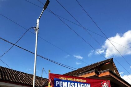 Sukarelawan Ganjar Muda Padjajaran (GMP) memasang lampu penerangan jalan umum (PJU) di Kampung Sukamaju, Desa Sukamukti, Cisayong, Tasikmalaya, Jawa Barat, Rabu (23/8). Foto: GMP