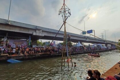 Sejumlah tim peserta (panjat pinang) berupaya meraih hadiah yang digantung dalam perlombaan panjat pinang di aliran Kalimalang yang digelar warga RW 04, Kelurahan Cipinang Melayu, Kecamatan Makasar, Jakarta Timur, Sabtu (19/8) siang. Foto: Joesvicar Iqbal/ipol.id