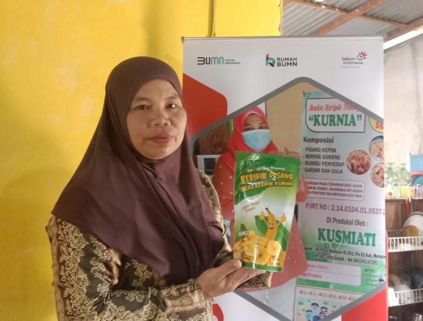 Kusmiati, pemiliki usaha Aneka Keripik Pisang “Kurnia” yang merupakan salah satu UMKM di Rumah BUMN Mempawah Kalimantan Barat yang telah melakukan upgrade packaging di bawah binaan Telkom. Foto: Telkom Indonesia