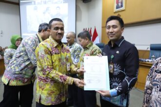 Wali Kota Jakarta Timur, Muhammad Anwar menyerahkan surat imbauan Pajak Kendaraan Bermotor (PKB) yang Belum Daftar Ulang (BDU) melalui para camat dalam Rapat Koordinasi Wilayah (Rakorwil) di Ruang Pola, Kantor Walikota Jakarta Timur, Kamis (21/9). Foto: Ist