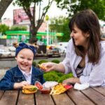 Ilustrasi - Seorang Ibu memberikan makanan kentang goreng kepada buah hatinya. Foto: Freepik