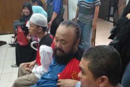 Terdakwa kasus dugaan penipuan Burhanuddin (tengah) mengenakan rompi tahanan warna merah. Foto: Istimewa