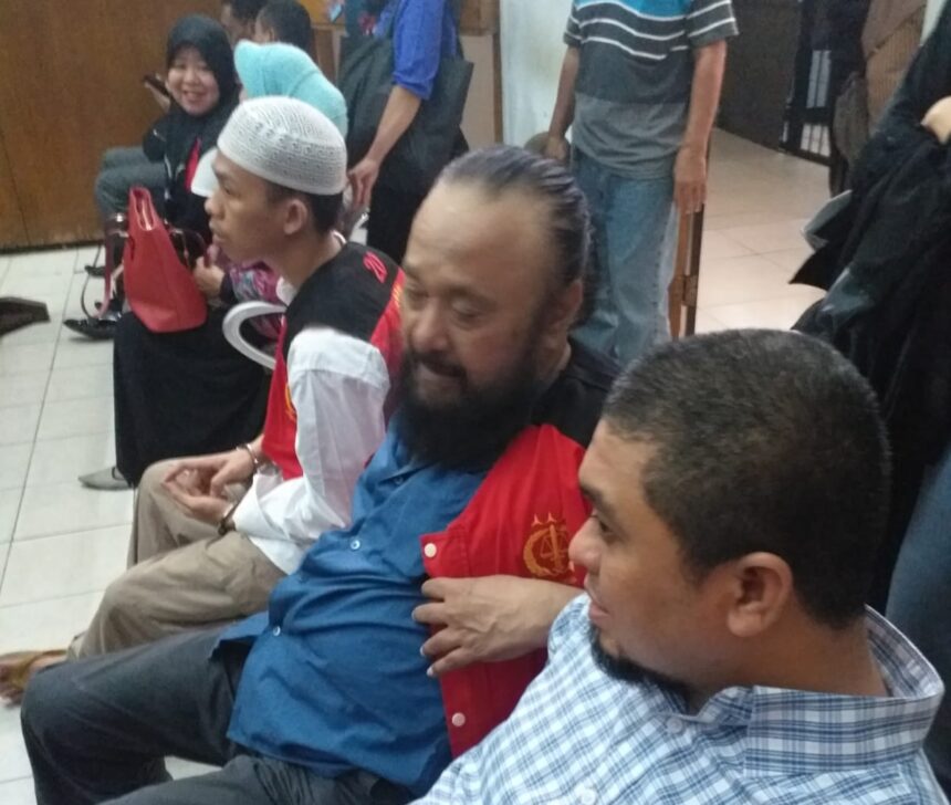 Terdakwa kasus dugaan penipuan Burhanuddin (tengah) mengenakan rompi tahanan warna merah. Foto: Istimewa