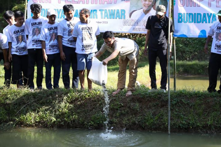 Koordinator Pusat Ganjar Muda Padjajaran (GMP), Randry Adryan Setiawan bersama sukarelawan memberikan bibit ikan dan pakan kepada warga di Kampung Wangunwati, Desa Sukawangun, Kecamatan Karangnunggal, Kabupaten Tasikmalaya, Jawa Barat, Rabu (13/9). Foto: GMP