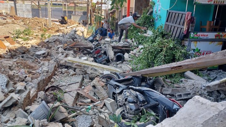 Sejumlah pekerja membersihkan puing reruntuhan yang menimpa empat unit motor dan tiga rumah yang rusak berat di Gang Anggrek, RT 05/RW 04, Kelurahan Klender, Kecamatan Duren Sawit, Jakarta Timur, Senin (25/9) siang tadi. Foto: Joesvicar Iqbal/ipol.id