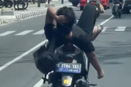 Dalam video yang menyebar di media sosial, pemotor Vario dengan merebahkan badannya ke jok belakang dan kakinya berada di setang kemudi. Foto: NTMC