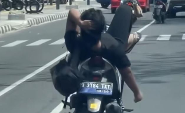 Dalam video yang menyebar di media sosial, pemotor Vario dengan merebahkan badannya ke jok belakang dan kakinya berada di setang kemudi. Foto: NTMC