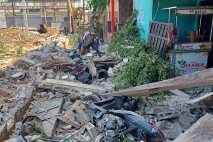 Sejumlah pekerja tengah membersihkan puing-puing reruntuhan usai tembok roboh menimpa empat unit motor dan tiga rumah di Gang Anggrek, RT 05/RW 04, Kelurahan Klender, Kecamatan Duren Sawit, Jakarta Timur, Senin (25/9) siang kemarin. Foto: Joesvicar Iqbal/ipol.id