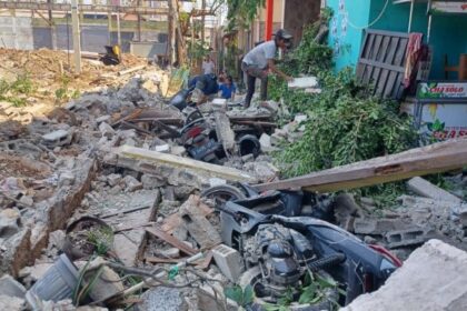 Sejumlah pekerja tampak tengah membersihkan puing-puing reruntuhan usai tembok roboh menimpa empat unit motor dan tiga rumah di Gang Anggrek, RT 05/RW 04, Kelurahan Klender, Kecamatan Duren Sawit, Jakarta Timur, Senin (25/9) siang. Foto: Joesvicar Iqbal/ipol.id