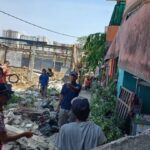 Warga setempat mengecek lokasi reruntuhan usai tembok menimpa empat unit motor dan tiga rumah yang rusak berat di Gang Anggrek, RT 05/RW 04, Kelurahan Klender, Kecamatan Duren Sawit, Jakarta Timur, Senin (25/9) siang. Foto: Joesvicar Iqbal/ipol.id