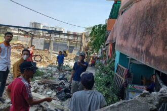 Warga setempat mengecek lokasi reruntuhan usai tembok menimpa empat unit motor dan tiga rumah yang rusak berat di Gang Anggrek, RT 05/RW 04, Kelurahan Klender, Kecamatan Duren Sawit, Jakarta Timur, Senin (25/9) siang. Foto: Joesvicar Iqbal/ipol.id