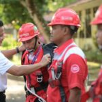 Ketua Satgas KTT AIS Forum 2023 TelkomGroup, Syaifudin secara simbolis menyematkan perlengkapan kerja kepada perwakilan teknisi lapangan yang bertugas dalam pengawalan infrastruktur, jaringan, dan layanan TelkomGroup selama penyelenggaraan KTT, Nusa Dua Bali (6/10). (Dok Telkom Indonesia)