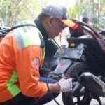 Seorang petugas Suku Dinas (Sudin) Lingkungan Hidup (LH) Kota Administrasi Jakarta Selatan melakukan uji emisi kendaraan roda dua milik warga di Kantor Kecamatan Tebet, Rabu (11/10). Foto: Ist